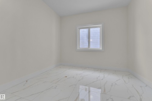 Empty room with baseboards and light marble finish flooring - 231 Crystal Creek Drive, Leduc, AB - Indoor Photo Showing Other Room
