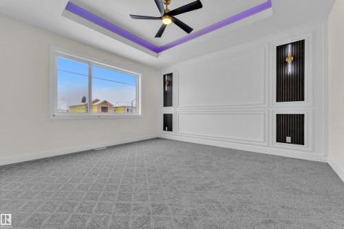 Empty room featuring a tray ceiling, carpet flooring, and a ceiling fan - 231 Crystal Creek Drive, Leduc, AB - Indoor Photo Showing Other Room