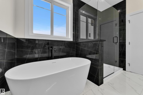 Full bath featuring a stall shower, a soaking tub, tile walls, and light marble finish floors - 231 Crystal Creek Drive, Leduc, AB - Indoor Photo Showing Bathroom