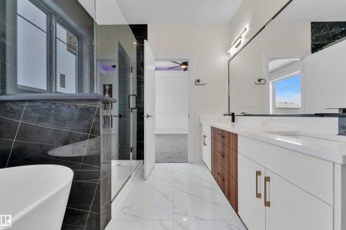 Bathroom with a shower stall, double vanity, a freestanding bath, ceiling fan, and light marble finish flooring - 231 Crystal Creek Drive, Leduc, AB - Indoor Photo Showing Bathroom