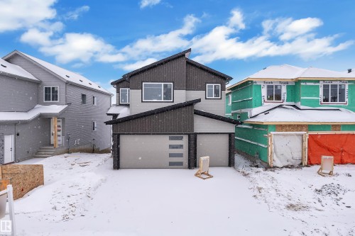 Snow covered house with a garage and an outdoor structure - 231 Crystal Creek Drive, Leduc, AB - Outdoor