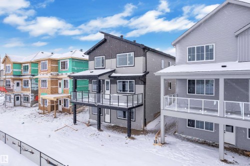 Snow covered back of property with a residential view and a deck - 231 Crystal Creek Drive, Leduc, AB - Outdoor