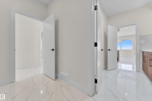 Hall with baseboards and light marble finish flooring - 231 Crystal Creek Drive, Leduc, AB - Indoor Photo Showing Other Room