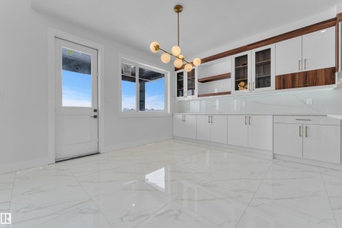 Unfurnished dining area featuring hanging lights and light marble finish flooring - 231 Crystal Creek Drive, Leduc, AB - Indoor