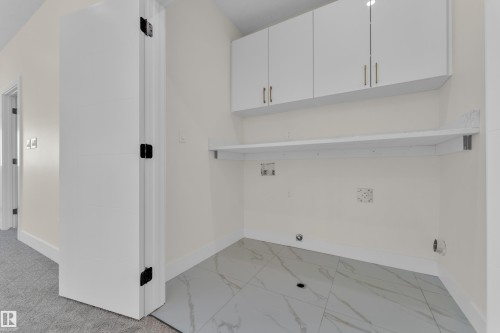 Laundry area featuring light marble finish flooring, washer hookup, cabinet space, and gas dryer hookup - 231 Crystal Creek Drive, Leduc, AB - Indoor Photo Showing Other Room