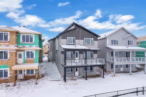 View of the back of the house featuring a residential view, a deck, and brick siding - 231 Crystal Creek Drive, Leduc, AB - Outdoor With Facade