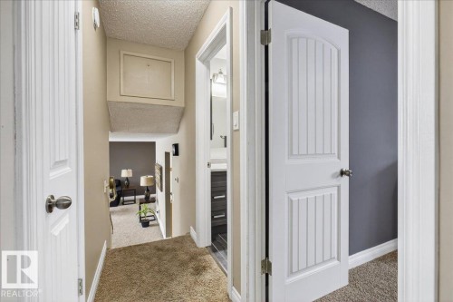 Corridor with a textured ceiling and light carpet - 8804 38 Avenue, Edmonton, AB - Indoor Photo Showing Other Room