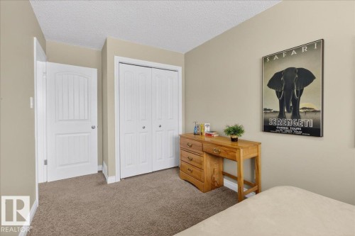 Bedroom with carpet, a textured ceiling, and a closet - 8804 38 Avenue, Edmonton, AB - Indoor Photo Showing Bedroom