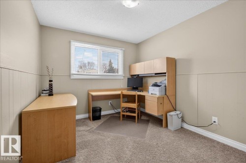 Office area with light colored carpet, a textured ceiling, wainscoting, and wooden walls - 8804 38 Avenue, Edmonton, AB - Indoor Photo Showing Office