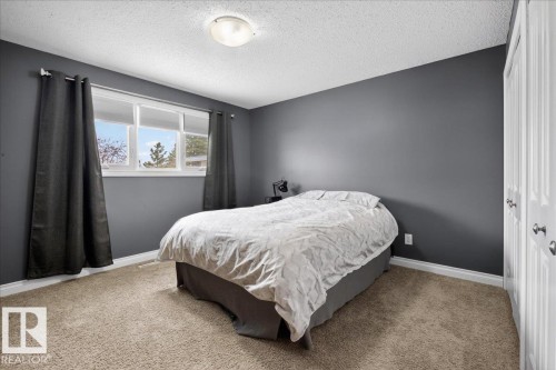 Carpeted bedroom featuring a textured ceiling and a closet - 8804 38 Avenue, Edmonton, AB - Indoor Photo Showing Bedroom