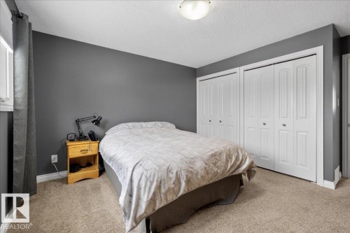 Bedroom with two closets, carpet, and a textured ceiling - 8804 38 Avenue, Edmonton, AB - Indoor Photo Showing Bedroom