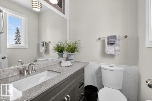 Half bath featuring vanity, tile walls, and wainscoting - 8804 38 Avenue, Edmonton, AB - Indoor Photo Showing Bathroom