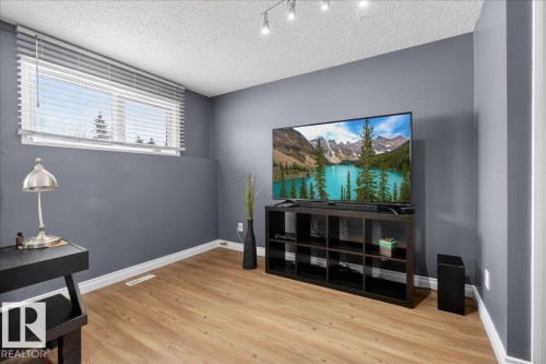 Living area with a textured ceiling and light wood-style flooring - 8804 38 Avenue, Edmonton, AB - Indoor Photo Showing Other Room