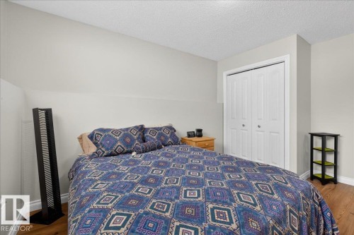 Bedroom featuring a textured ceiling, a closet, and dark wood finished floors - 8804 38 Avenue, Edmonton, AB - Indoor Photo Showing Bedroom