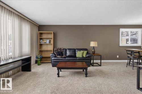 Living area featuring light carpet and a textured ceiling - 8804 38 Avenue, Edmonton, AB - Indoor