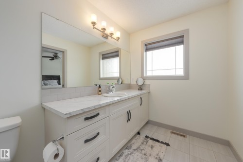 Bathroom featuring vanity, light tile patterned flooring, and connected bathroom - 17528 58 Street, Edmonton, AB - Indoor Photo Showing Bathroom