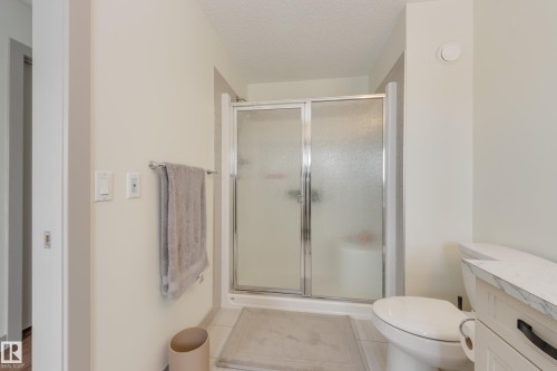 Bathroom featuring a shower stall, a textured ceiling, vanity, and light tile patterned floors - 17528 58 Street, Edmonton, AB - Indoor Photo Showing Bathroom