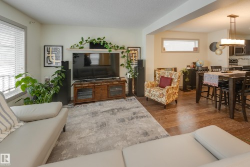 Living room with dark wood finished floors, a textured ceiling, and healthy amount of natural light - 17528 58 Street, Edmonton, AB - Indoor Photo Showing Living Room