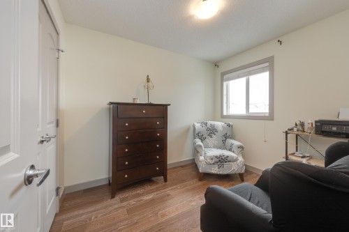 Living area featuring wood finished floors and a textured ceiling - 17528 58 Street, Edmonton, AB - Indoor