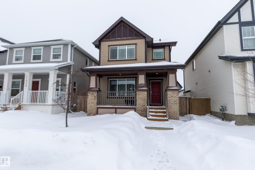 View of front of home with a porch, brick siding, and board and batten siding - 17528 58 Street, Edmonton, AB - Outdoor With Deck Patio Veranda With Facade