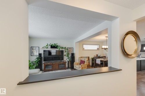 Living room featuring a textured ceiling and wood finished floors - 17528 58 Street, Edmonton, AB - Indoor Photo Showing Other Room