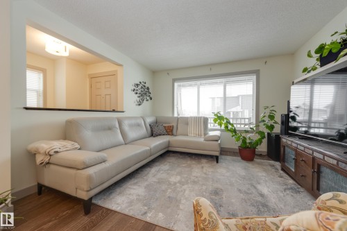 Living room featuring a textured ceiling and wood finished floors - 17528 58 Street, Edmonton, AB - Indoor Photo Showing Living Room