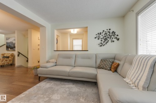 Living area featuring wood finished floors and a textured ceiling - 17528 58 Street, Edmonton, AB - Indoor Photo Showing Living Room