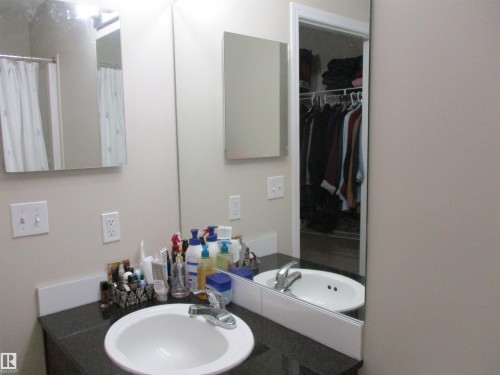 Full bath with vanity, a walk in closet, and curtained shower - 3309 9351 Simpson Drive, Edmonton, AB - Indoor Photo Showing Bathroom