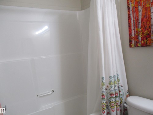 Full bath with shower / bathtub combination with curtain and toilet - 3309 9351 Simpson Drive, Edmonton, AB - Indoor Photo Showing Bathroom