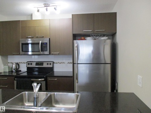 Kitchen with stainless steel appliances, decorative backsplash, and a textured ceiling - 3309 9351 Simpson Drive, Edmonton, AB - Indoor Photo Showing Kitchen With Double Sink With Upgraded Kitchen