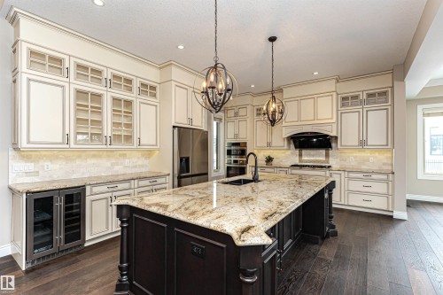 Kitchen with glass fronted cabinets, light stone counters, beverage cooler, dark wood finished floors, and dual tone cabinetry - 3520 Watson Point(E), Edmonton, AB - Indoor Photo Showing Kitchen With Upgraded Kitchen