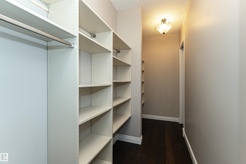 Walk in closet featuring dark wood finished floors - 3520 Watson Point(E), Edmonton, AB - Indoor With Storage