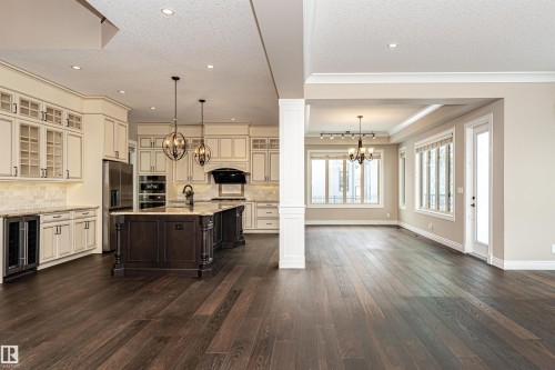 Kitchen with hanging lights, two tone cabinetry, glass insert cabinets, beverage cooler, and dark wood finished floors - 3520 Watson Point(E), Edmonton, AB - Indoor Photo Showing Kitchen With Upgraded Kitchen