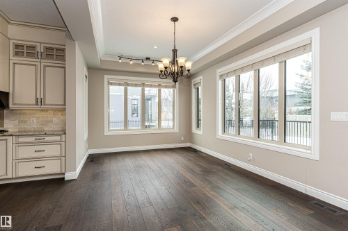Unfurnished dining area with dark wood-type flooring, a chandelier, and crown molding - 3520 Watson Point(E), Edmonton, AB - Indoor Photo Showing Other Room