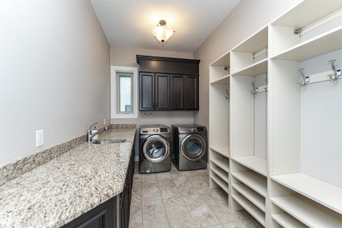 Laundry room featuring washer and clothes dryer, a textured ceiling, and cabinet space - 3520 Watson Point(E), Edmonton, AB - Indoor Photo Showing Laundry Room