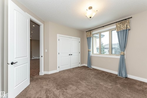 Unfurnished bedroom with dark carpet, a closet, and a textured ceiling - 3520 Watson Point(E), Edmonton, AB - Indoor Photo Showing Other Room