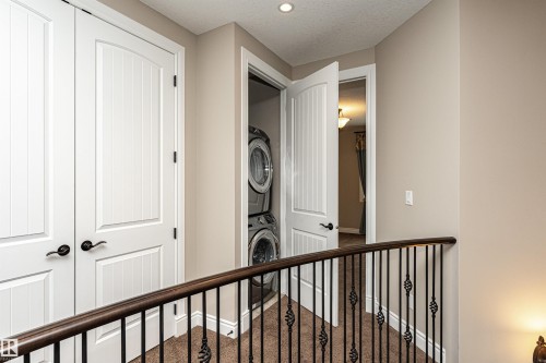 Corridor with carpet floors, stacked washing machine and dryer, and a textured ceiling - 3520 Watson Point(E), Edmonton, AB - Indoor Photo Showing Other Room