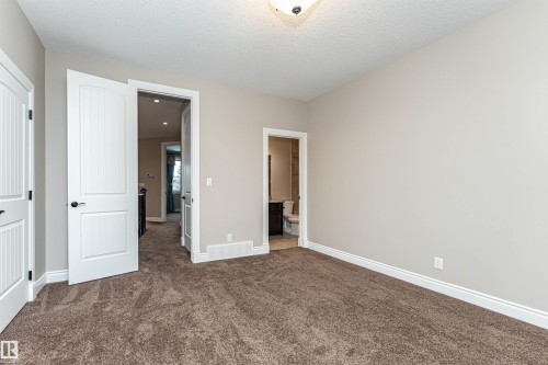 Unfurnished bedroom with dark carpet, ensuite bath, and a textured ceiling - 3520 Watson Point(E), Edmonton, AB - Indoor Photo Showing Other Room