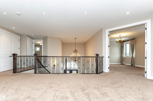 Carpeted empty room featuring hanging lights and a textured ceiling - 3520 Watson Point(E), Edmonton, AB - Indoor Photo Showing Other Room