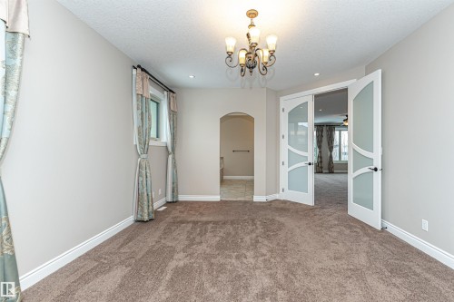 Unfurnished dining area with arched walkways, carpet, french doors, hanging lights, and a textured ceiling - 3520 Watson Point(E), Edmonton, AB - Indoor Photo Showing Other Room