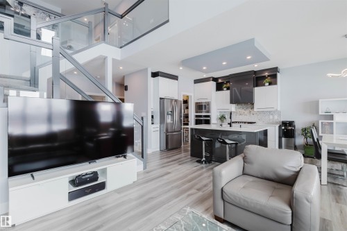 Living room with light wood-style flooring and suspended lighting - 16217 32 Avenue, Edmonton, AB - Indoor Photo Showing Living Room