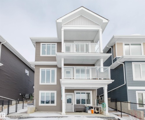 Back of house featuring a balcony, a gate, and board and batten siding - 16217 32 Avenue, Edmonton, AB - Outdoor With Balcony With Facade