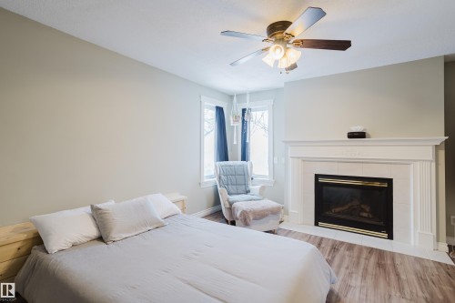 Features gas fireplace - 13143 37 Street, Edmonton, AB - Indoor Photo Showing Bedroom With Fireplace