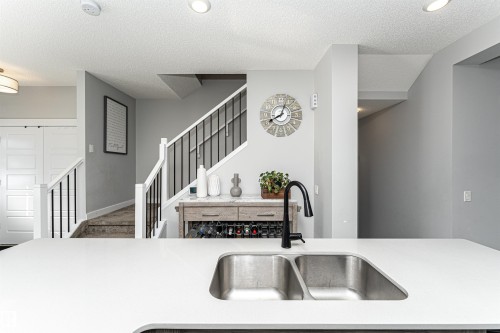 Kitchen featuring a textured ceiling and light stone countertops - 16616 31 Avenue, Edmonton, AB - Indoor Photo Showing Kitchen