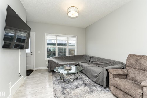 Living area featuring light wood-type flooring and a textured ceiling - 16616 31 Avenue, Edmonton, AB - Indoor Photo Showing Living Room