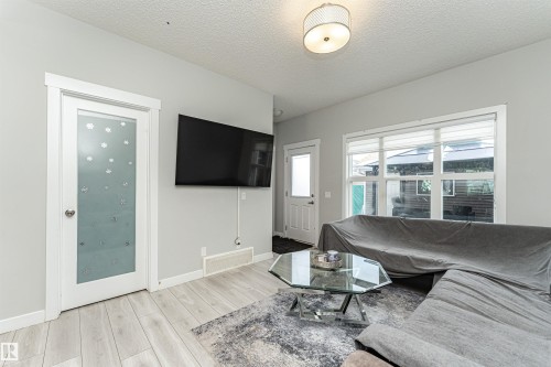 Living area featuring light wood-type flooring and a textured ceiling - 16616 31 Avenue, Edmonton, AB - Indoor Photo Showing Living Room