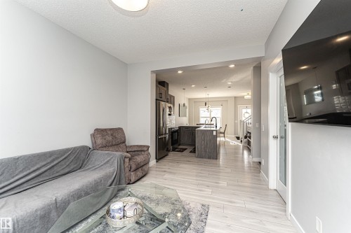 Living room featuring a textured ceiling, light wood-style flooring, and recessed lighting - 16616 31 Avenue, Edmonton, AB - Indoor