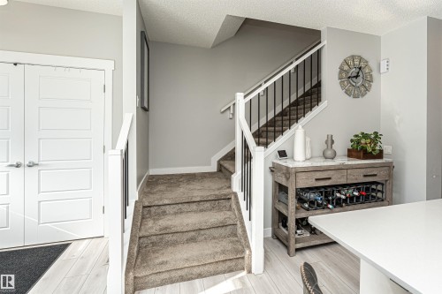 Staircase featuring a textured ceiling and wood finished floors - 16616 31 Avenue, Edmonton, AB - Indoor Photo Showing Other Room