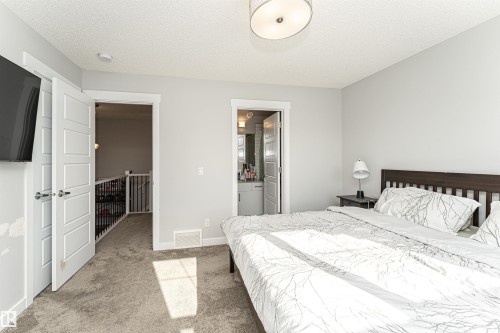 Bedroom with light carpet, a textured ceiling, and connected bathroom - 16616 31 Avenue, Edmonton, AB - Indoor Photo Showing Bedroom