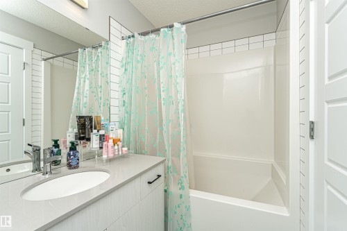 Bathroom featuring vanity, a textured ceiling, and shower / bathtub combination with curtain - 16616 31 Avenue, Edmonton, AB - Indoor Photo Showing Bathroom